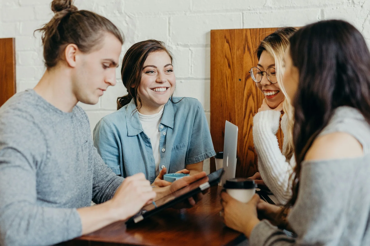 Four people sharing ideas around a table in a coffee shop.
